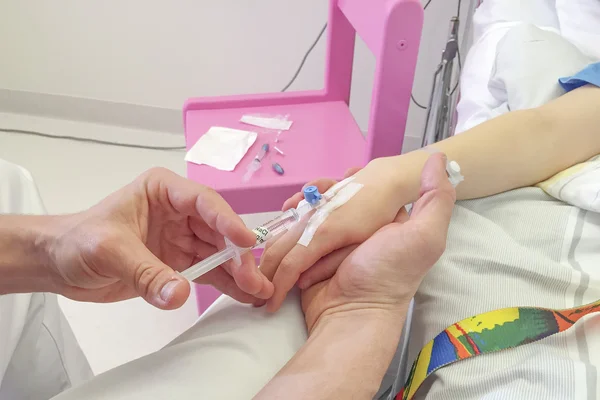 Niño joven recibiendo la inyección de glucosa en la vena Imagen de archivo