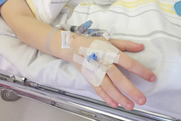 Niño joven recibiendo la inyección de glucosa en la vena Imágenes de stock libres de derechos