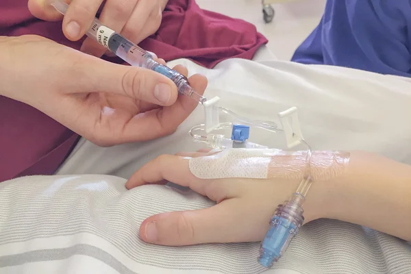 Niño joven recibiendo la inyección de glucosa en la vena Fotos de stock