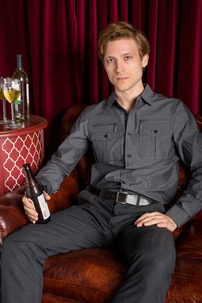 Man drinking beer on couch — Stock Photo, Image