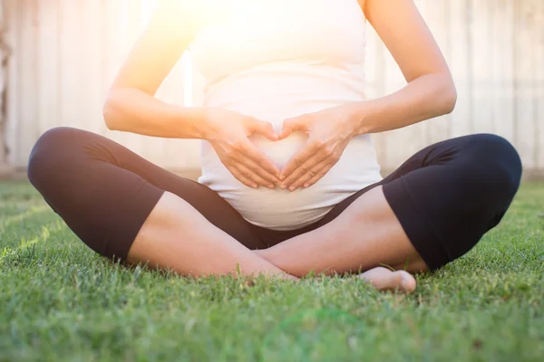 Hart van de zwangere vrouw op buik — Stockfoto
