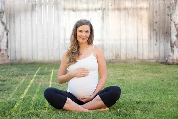 Donna incinta seduta fuori — Foto Stock