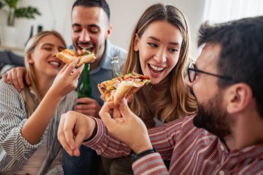 Karantina eğlencesi. Arkadaşlar evde eğleniyor, pizza yiyor. İnsanlar, eğlence ve yaşam tarzı konsepti.