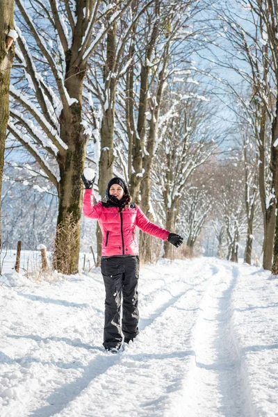 Giovane donna che lancia una palla di neve — Foto Stock