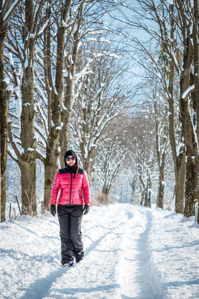Caminata en nieve con crampones ligeros. una mujer joven