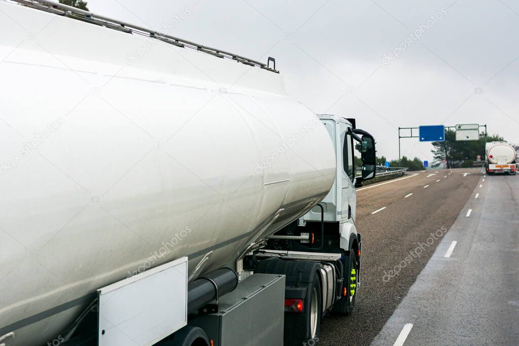 Two fuel tanker trucks driving on the highway.