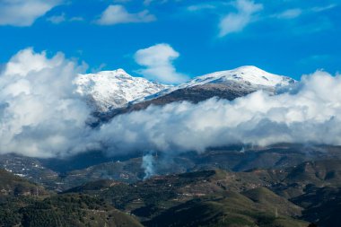Sierra Nevada 'nın güney yamacının manzarası, Pico del Caballo' nun zirvesi karla kaplı ve alçak bulutlarla çevrili..