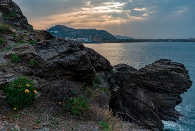 Biraz çiçekli kayalar, deniz ve taşralı Salobrena kasabası.