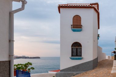 Pusula La Caleta 'nın kaldırımında yükseldi, bazı küçük sokak lambaları figürü aydınlattı..