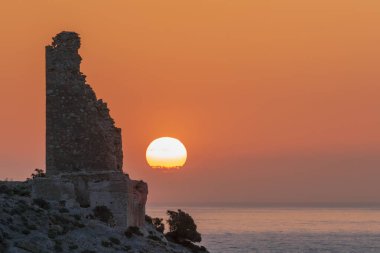 Arap döneminden kalma gözlem kulesinin kalıntıları şafakta güneşle birlikte, Rijana sahilinde, Costa Tropical, Granada.