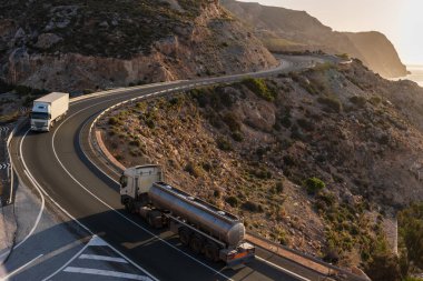 İki yönlü trafiği olan bir dağ yolunda iki kamyon..