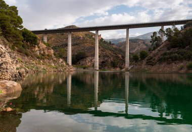 Nehrin üzerinde yeşil suları olan yüksek bir viyadük..