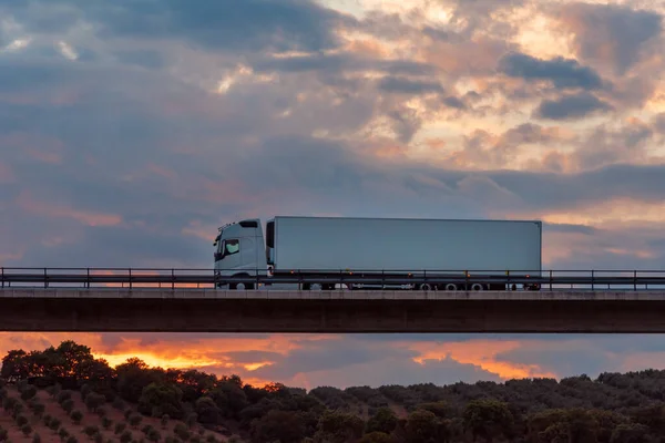 Gekoelde Vrachtwagen Rijdt Een Brug Met Een Dramatische Hemel Achtergrond — Stockfoto