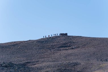 Group of hikers leaving a refuge on top of a mountain in Sierra Nevada, Granada