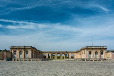 Versailles, Fransa - 28 Ağustos 2019 Versay 'daki ünlü Büyük Trianon Sarayı' nın iki kanadını birleştiren kaldırımlı taş avlunun ve korunaklı sütunların hoş panoramik manzarası