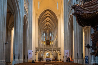 Leuven, Belçika - 14 Aralık 2025: Gotik naf ve Saint Peters Kilisesi 'nin ana sunağının simetrik görüntüsü, yükselen sütunlar ve kutsal mimari.