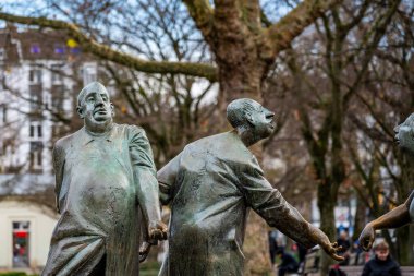 Aachen, Almanya - 04 Aralık 2024: Kamu meydanında Karl-Henning Seemann 'ın Kreislauf des Geldes heykelinin bronz figürlerine yakından bakmak.