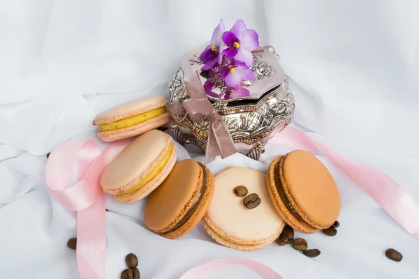Color macaroons and silver casket on a white background — Stock Photo, Image