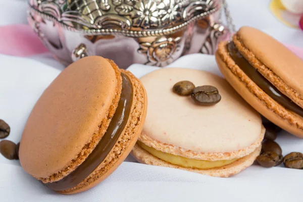 Color macaroons and silver casket on a white background — Stock Photo, Image