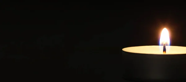 Arka planı bulanık, siyah bir masada sarı alevli mumlar yakmak. Noel mumları. Geceleri kilisede mum yakardı.