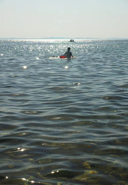 Enfant flottant sur un bateau gonflable avec gilet gonflable — Photo