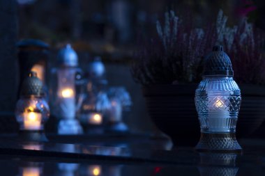 Mezarlıktaki siyah taş anıtın üzerinde geceleri yanan bir mum. Merhumun anıları. Aşkın ifadesi