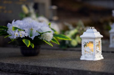 Mezarlıktaki siyah taş anıtın üzerinde geceleri yanan bir mum. Merhumun anıları. Aşkın ifadesi