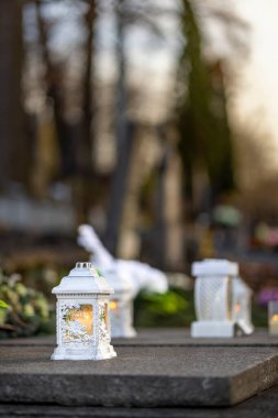 Mezarlıktaki siyah taş anıtın üzerinde geceleri yanan bir mum. Merhumun anıları. Aşkın ifadesi