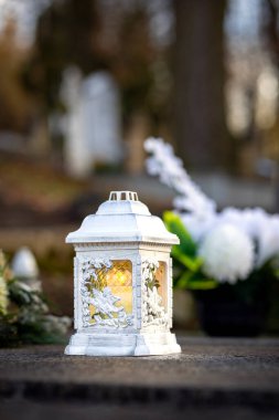 Mezarlıktaki siyah taş anıtın üzerinde geceleri yanan bir mum. Merhumun anıları. Aşkın ifadesi