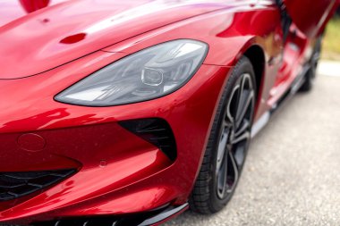 Kırmızı kaputun ayrıntıları ve spor araba ışığı. Klasik lüks bir arabanın maskesi.