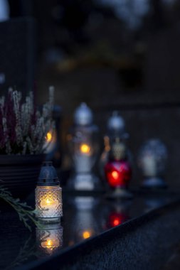 Mezarlıktaki siyah taş anıtın üzerinde geceleri yanan bir mum. Merhumun anıları. Aşkın ifadesi