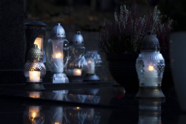 Mezarlıktaki siyah taş anıtın üzerinde geceleri yanan bir mum. Merhumun anıları. Aşkın ifadesi