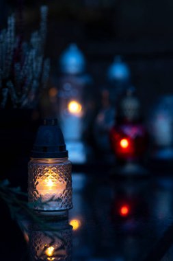 Mezarlıktaki siyah taş anıtın üzerinde geceleri yanan bir mum. Merhumun anıları. Aşkın ifadesi