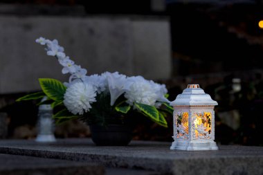 Mezarlıktaki siyah taş anıtın üzerinde geceleri yanan bir mum. Merhumun anıları. Aşkın ifadesi