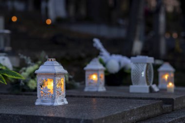 Mezarlıktaki siyah taş anıtın üzerinde geceleri yanan bir mum. Merhumun anıları. Aşkın ifadesi