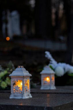 Mezarlıktaki siyah taş anıtın üzerinde geceleri yanan bir mum. Merhumun anıları. Aşkın ifadesi