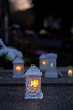 Mezarlıktaki siyah taş anıtın üzerinde geceleri yanan bir mum. Merhumun anıları. Aşkın ifadesi