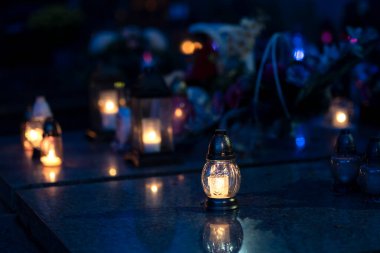 Mezarlıktaki siyah taş anıtın üzerinde geceleri yanan bir mum. Merhumun anıları. Aşkın ifadesi