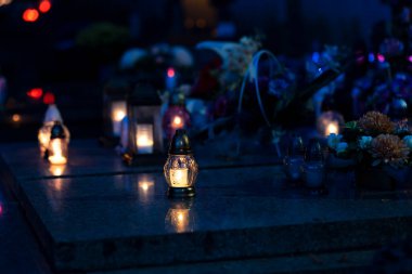 Mezarlıktaki siyah taş anıtın üzerinde geceleri yanan bir mum. Merhumun anıları. Aşkın ifadesi