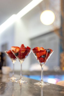 Karışık organik böğürtlenli cam kavanozlar yaban mersinli ahududu elması. Masada sağlıklı kırmızı meyveler var.