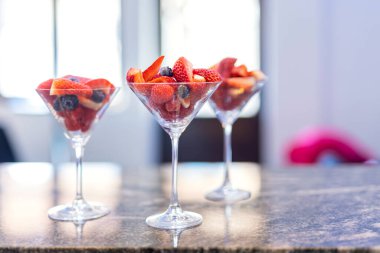 Karışık organik böğürtlenli cam kavanozlar yaban mersinli ahududu elması. Masada sağlıklı kırmızı meyveler var.