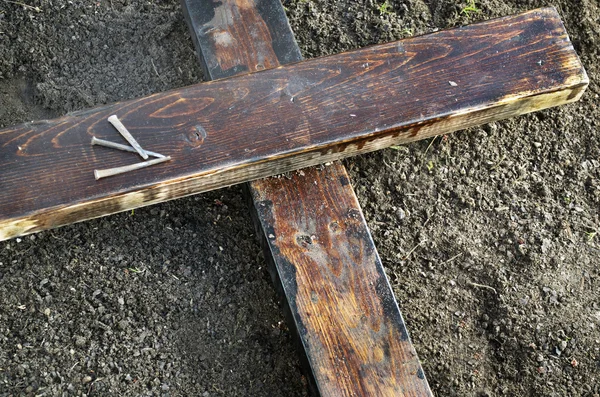 Stary drewniany krzyż na ziemi z trzech paznokci — Zdjęcie stockowe