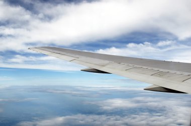 Uçağın kanat ve mavi gökyüzü ile görünümünden