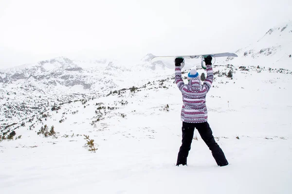 Soğuk kış gününde snowboard yapan bir kadın. Kötü hava. Fırtına..