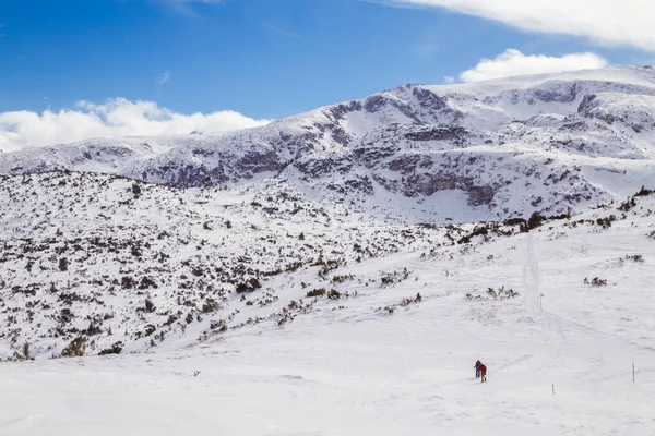 Két turista túrázás a téli hegyekben Rila, Bulgária. — Stock Fotó