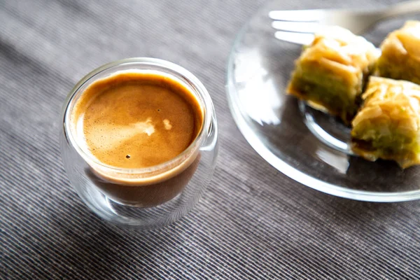 Close up transparante koffiebeker op tafel met zoet dessert op de achtergrond. Rechtenvrije Stockafbeeldingen