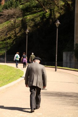 Parkta yürüyen yaşlı insanlar.
