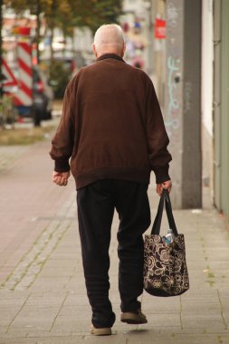 Parkta yürüyen yaşlı insanlar.