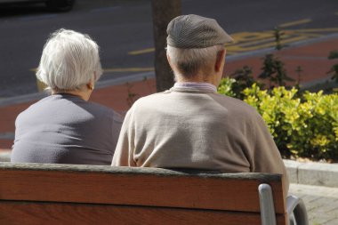 Parkta yürüyen yaşlı insanlar.