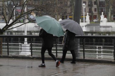 Yağmurun altında şemsiyeyle yürüyorum